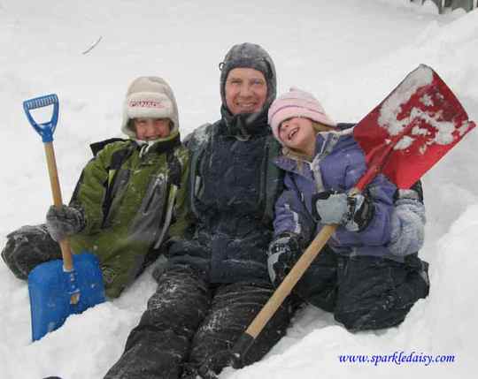 Children and adult playing in the snow